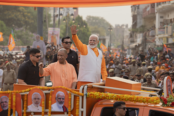 Modi on orange truck amidst crowd